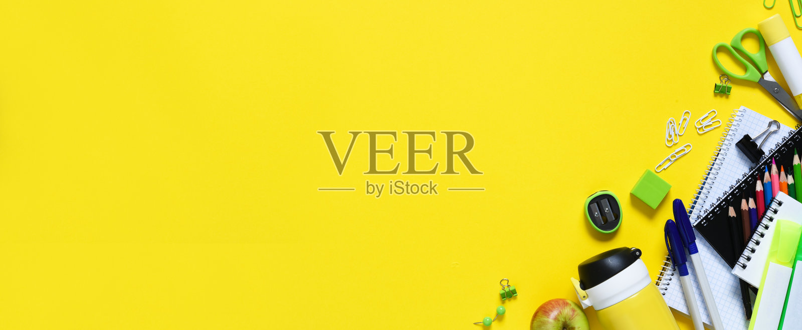 回到学校。黄色背景上的学校用品和一个苹果。布置学校用品。远程学习。照片摄影图片