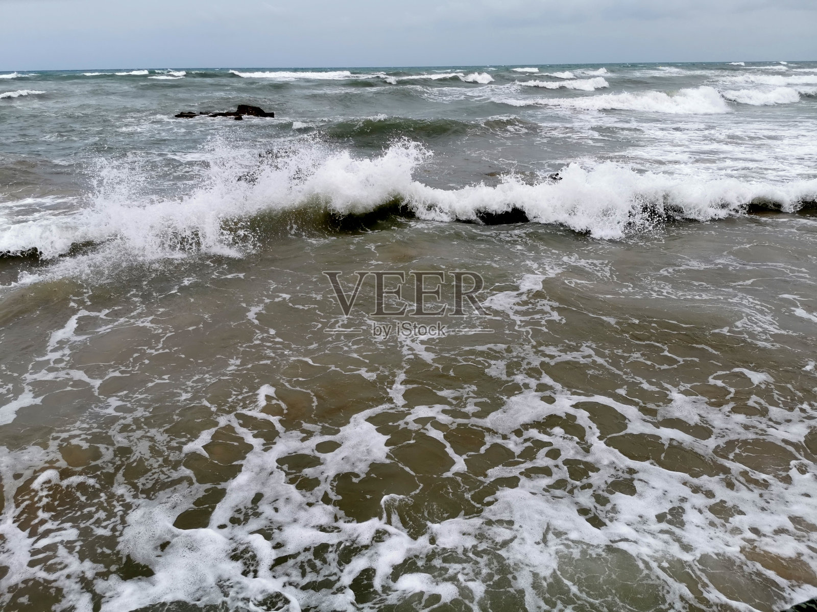 海浪拍打着海岸外的卵石照片摄影图片