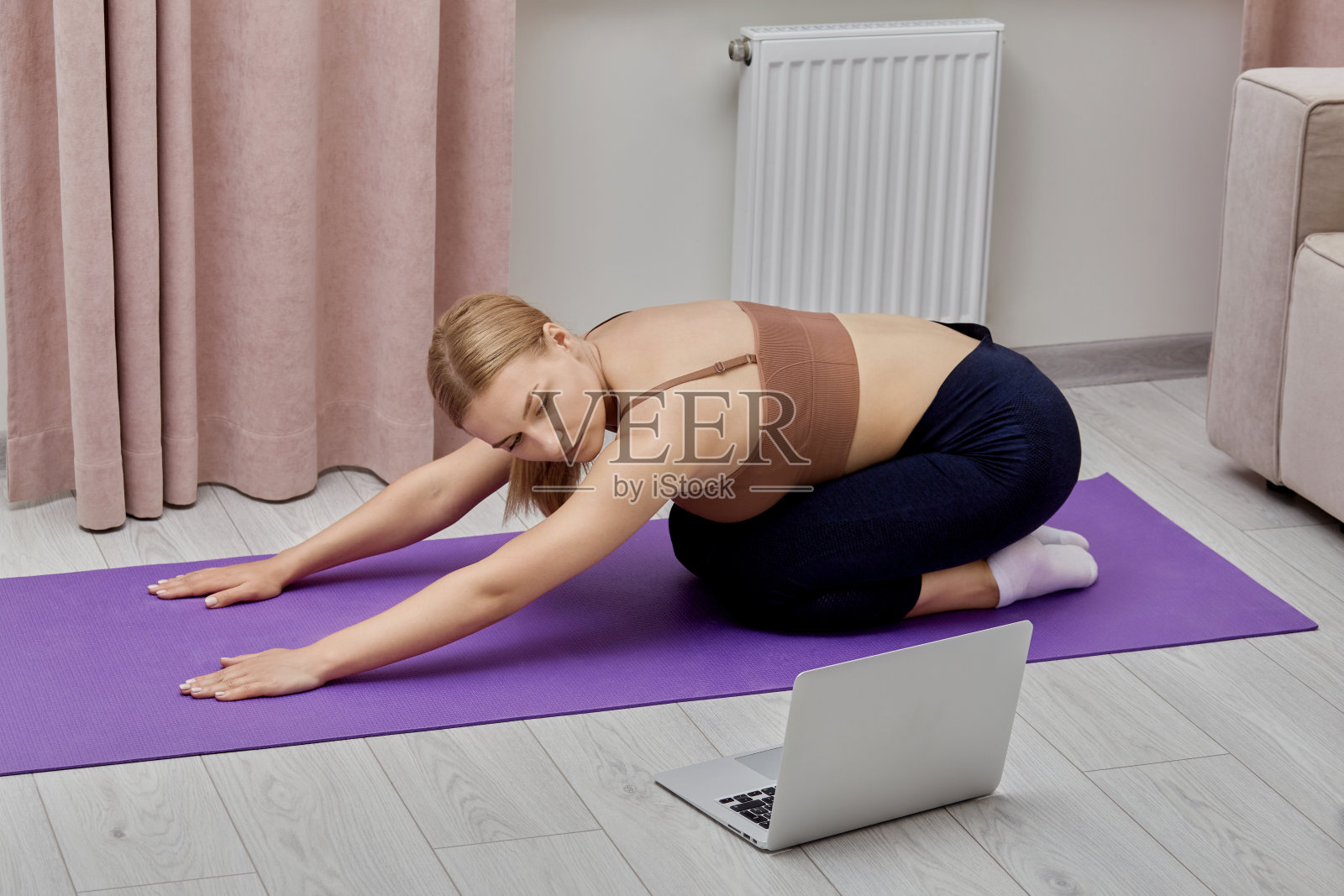 年轻苗条的女人在家里上网运动。照片摄影图片