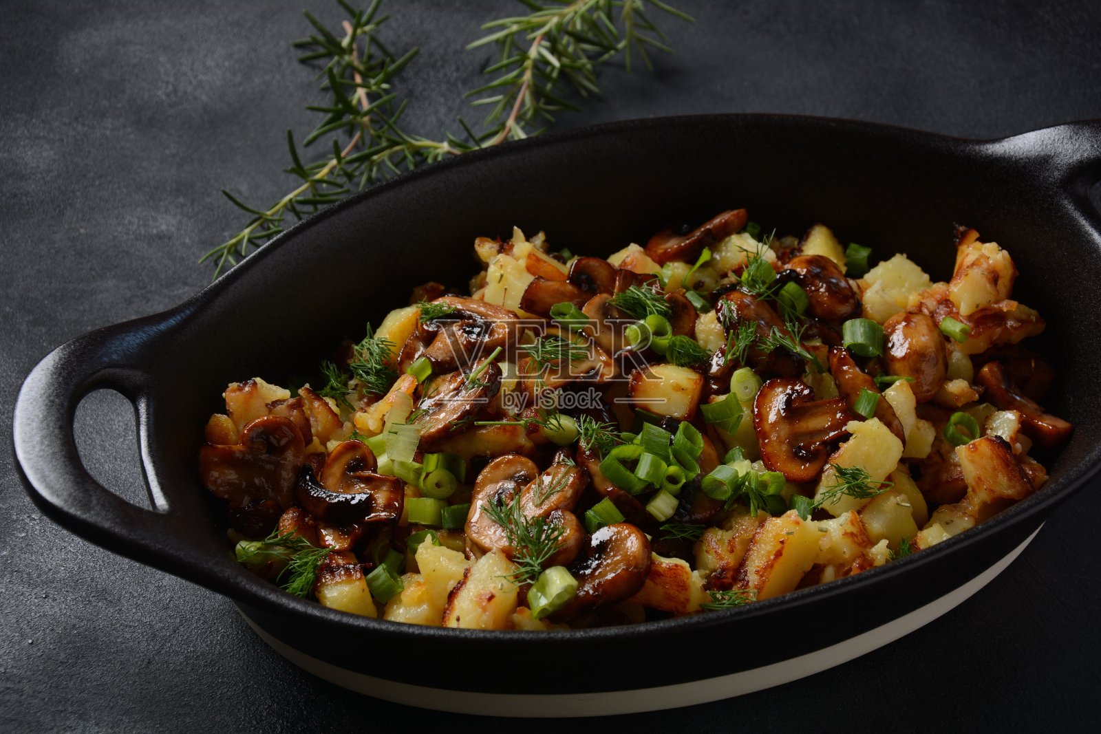 盘子里/炸碗里放着加了香草的蘑菇炸土豆照片摄影图片