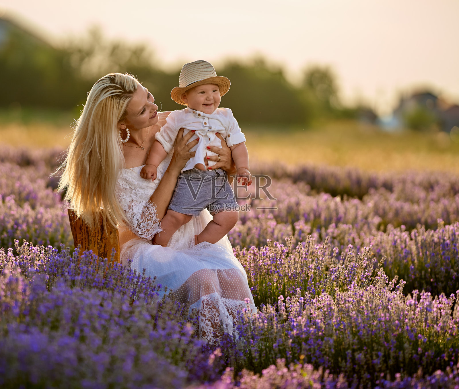 年轻的母亲和她的儿子在薰衣草地里照片摄影图片