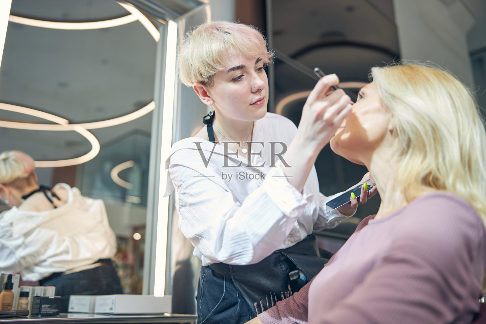 专注的年轻美容师做专业的老化化妆照片摄影图片
