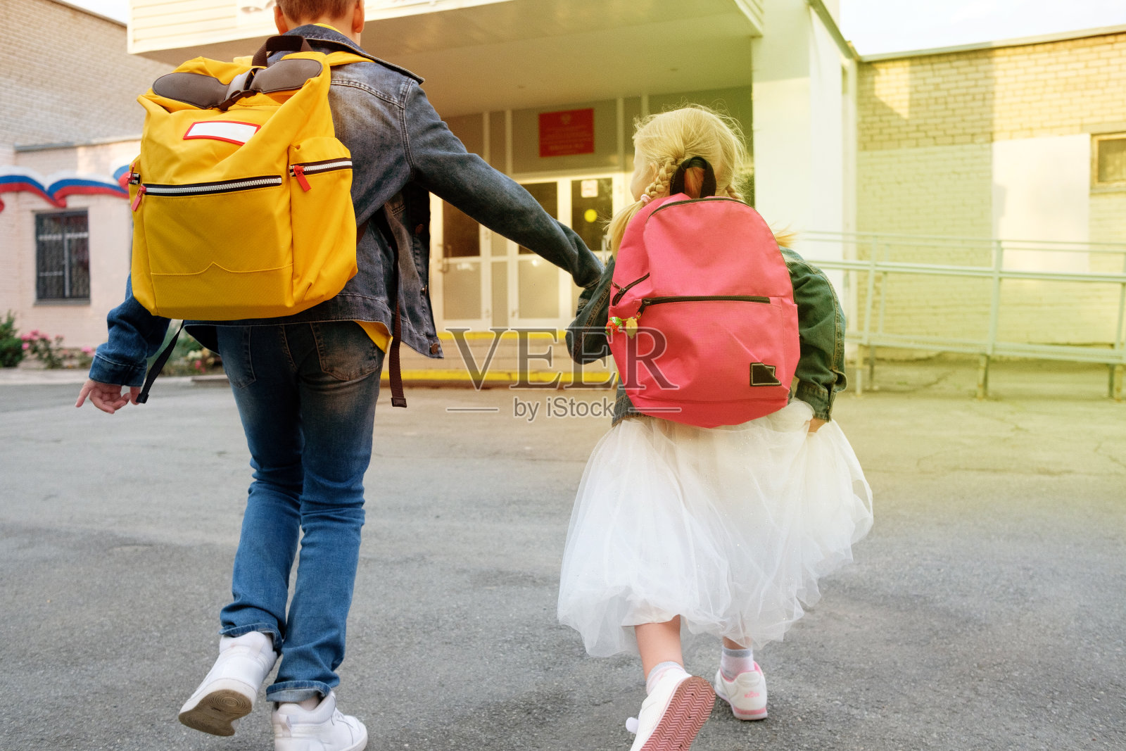 男孩和女孩手拉着手跑去学校照片摄影图片