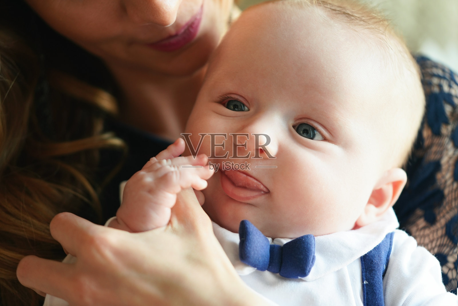 年轻的母亲和她的儿子，头部贴近，她要亲吻他的头部照片摄影图片