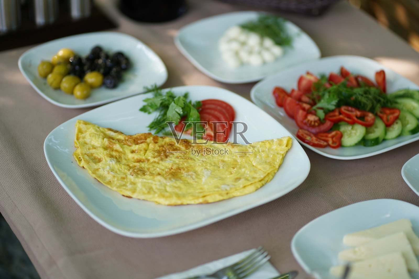 早餐桌上放着煎蛋卷、橄榄、奶酪和早餐食品照片摄影图片