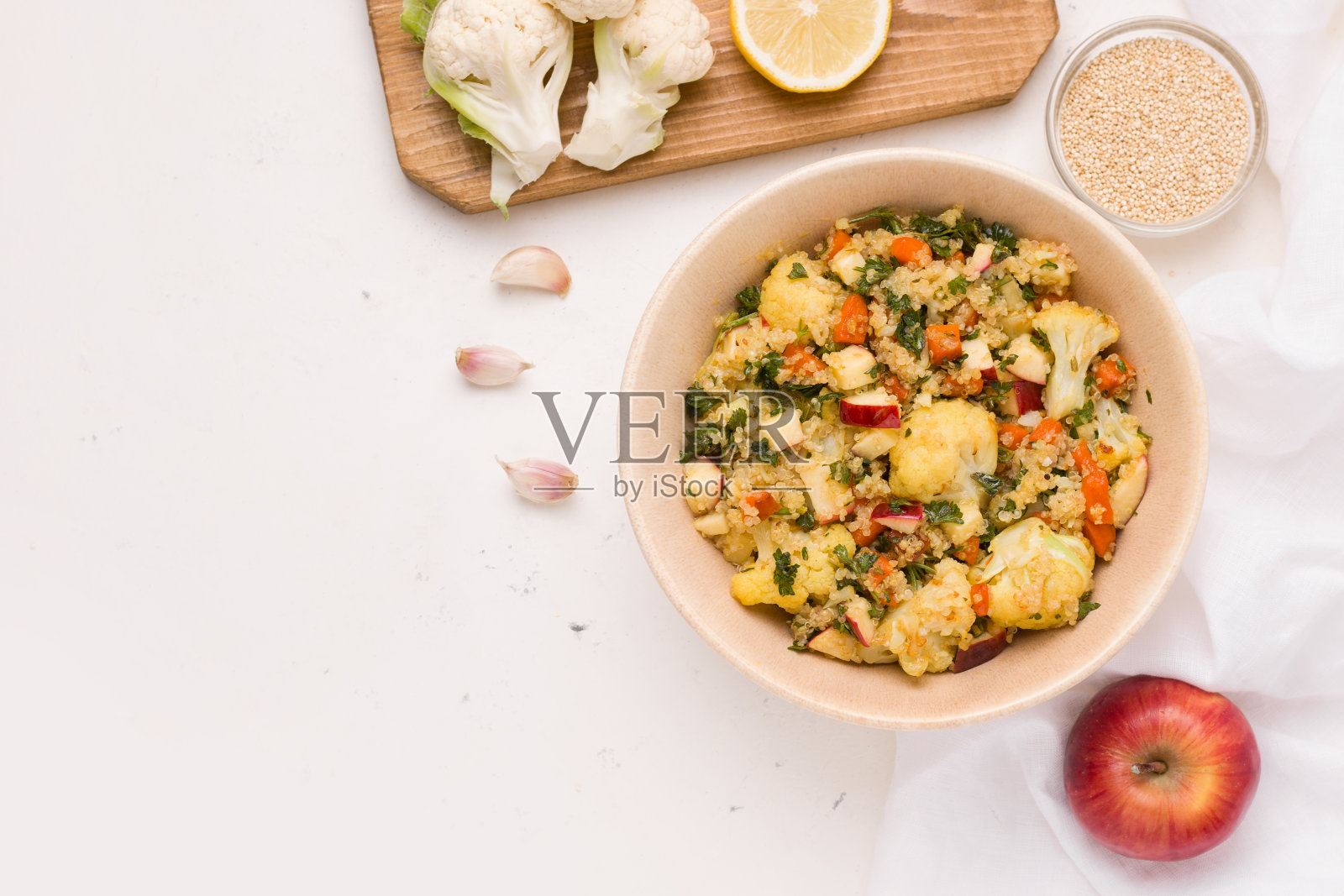 白色盘子上放有花椰菜，藜麦，柠檬汁苹果和欧芹。本空间照片摄影图片