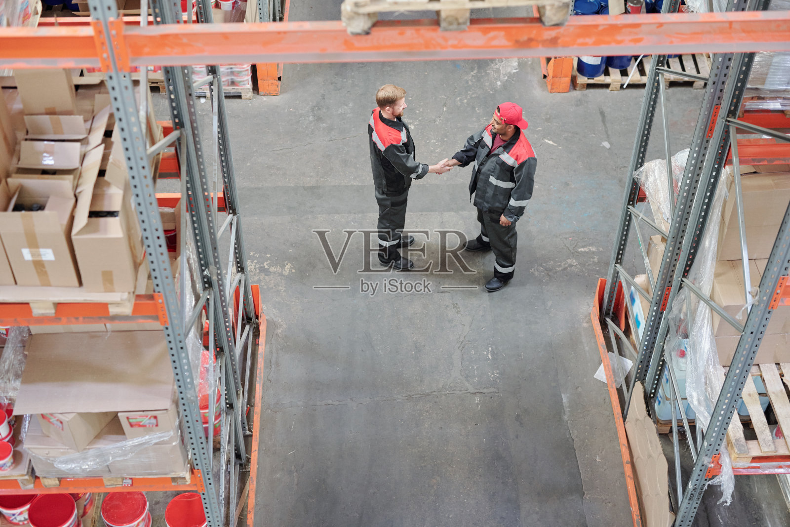 两位年轻的跨文化仓库经理握手概述照片摄影图片