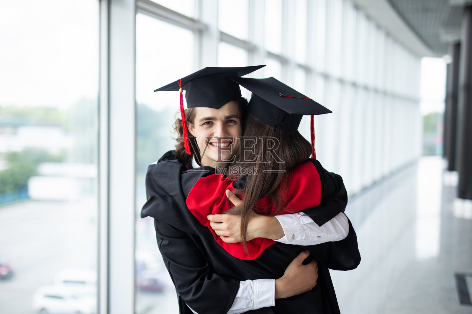 毕业生们欣然接受。美丽的毕业生夫妇享受了毕业典礼。照片摄影图片