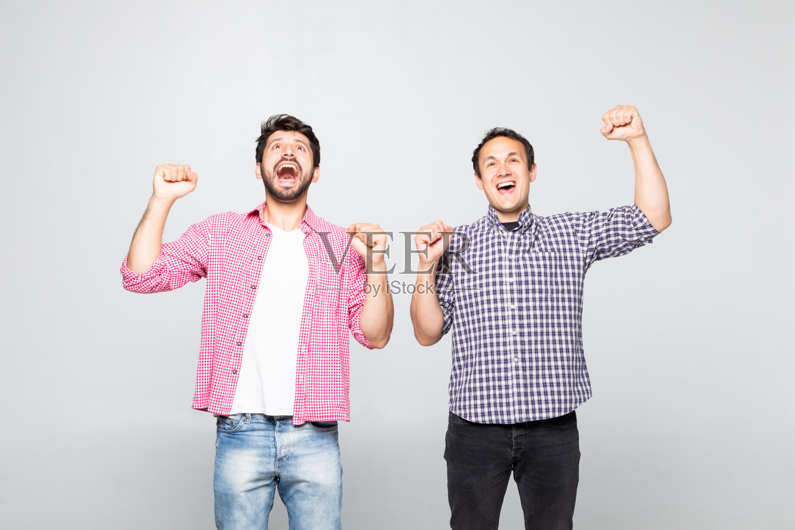 两个快乐的年轻人在黄色背景上庆祝孤立的肖像照片摄影图片