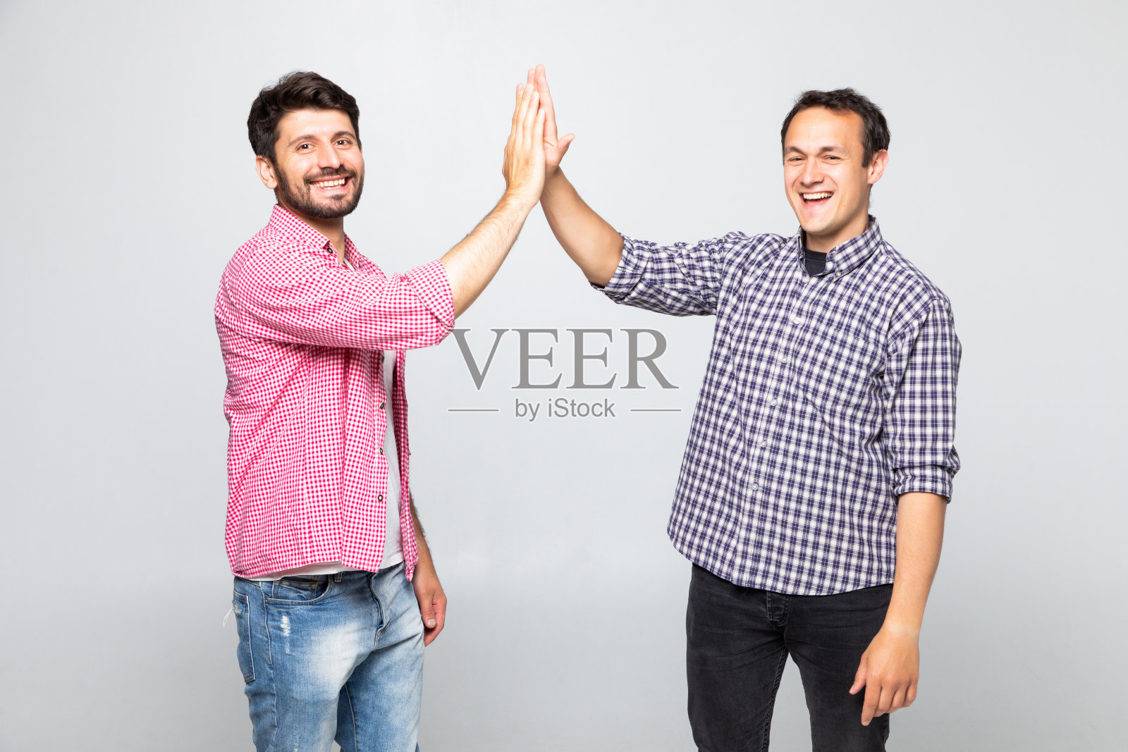 两个快乐的年轻人在白色的背景下互相击掌照片摄影图片