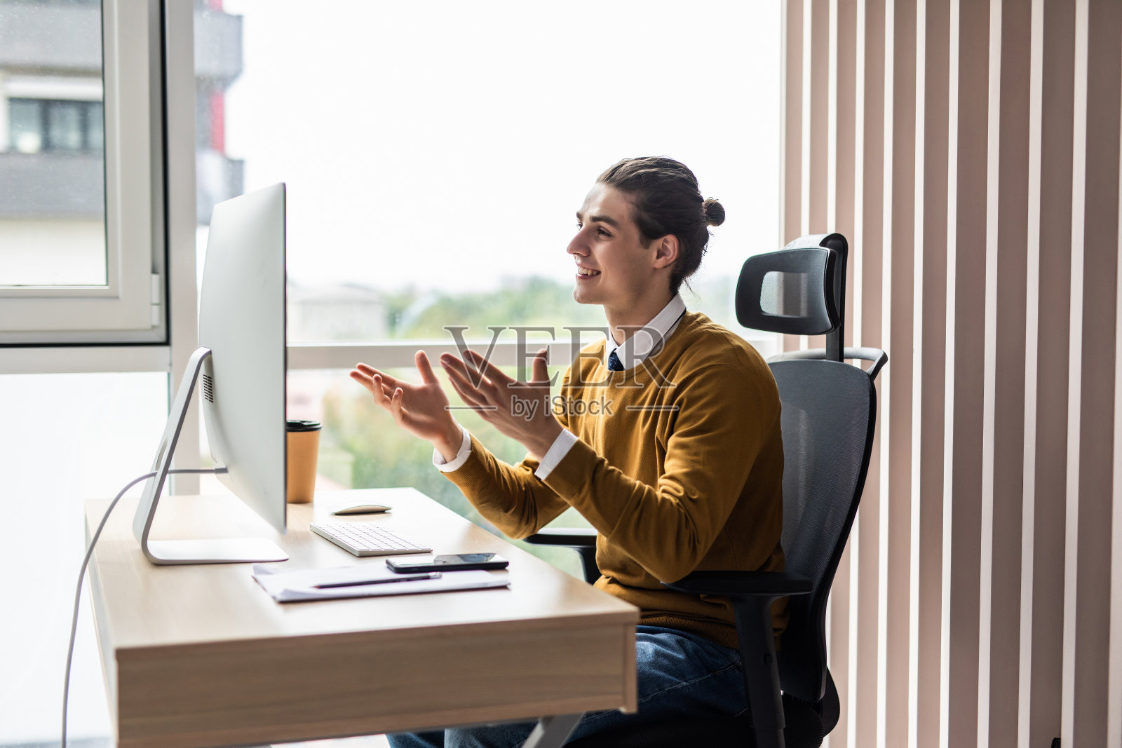 年轻的商人与他的同事在办公室的台式电脑上进行视频通话照片摄影图片