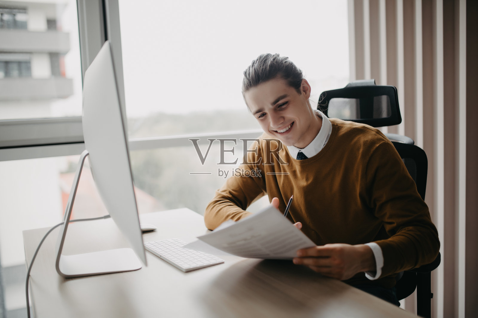 年轻帅气的商人坐在家里的桌子前在电脑屏幕上写便条照片摄影图片