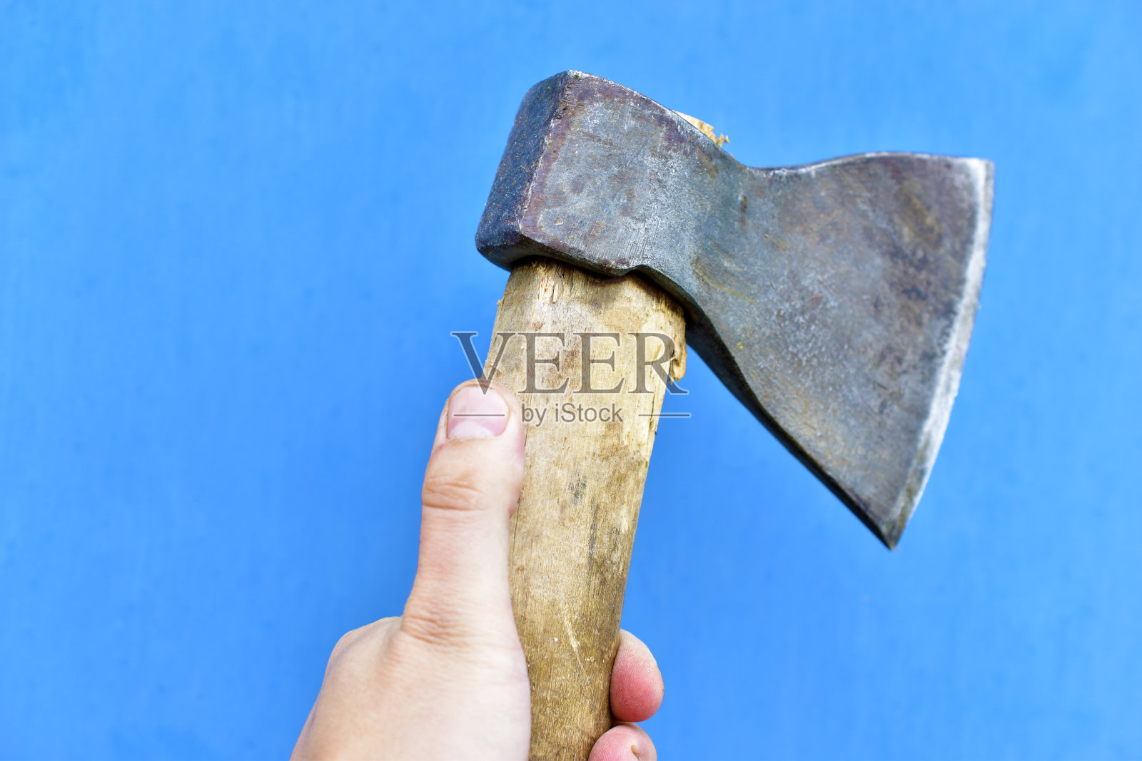蓝色背景上的木柄铁斧照片摄影图片