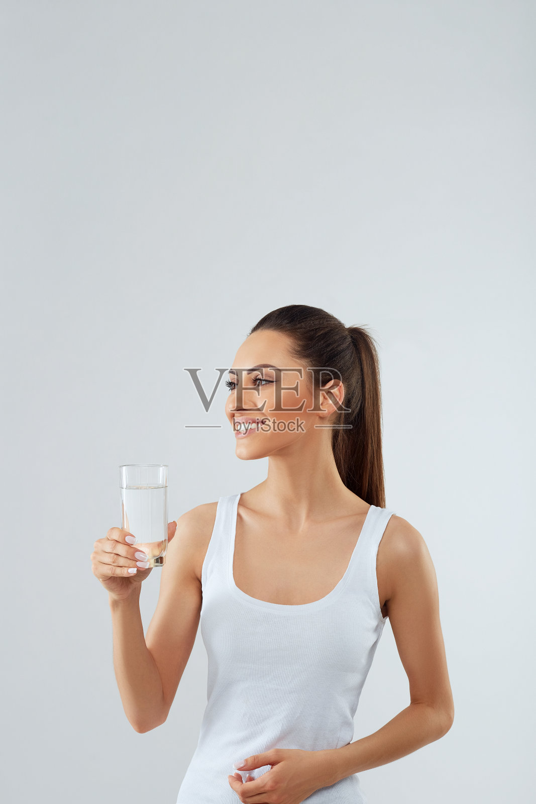 玻璃水。美丽的女孩hold住了水。白色背景隔离。喝水。饮食概念照片摄影图片