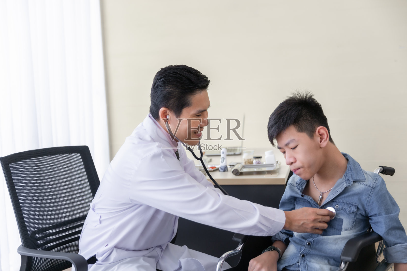 亚洲医生用听诊器检查残疾人轮椅患者，残疾人的健康理念照片摄影图片