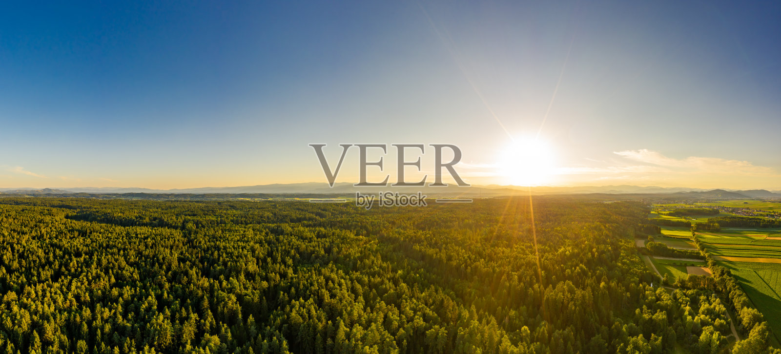 空中全景图的乡村在阳光明媚的冬天在斯蒂里亚，奥地利。在阳光、蓝天、绿色田野的美丽自然景观中穿行。背景照片摄影图片