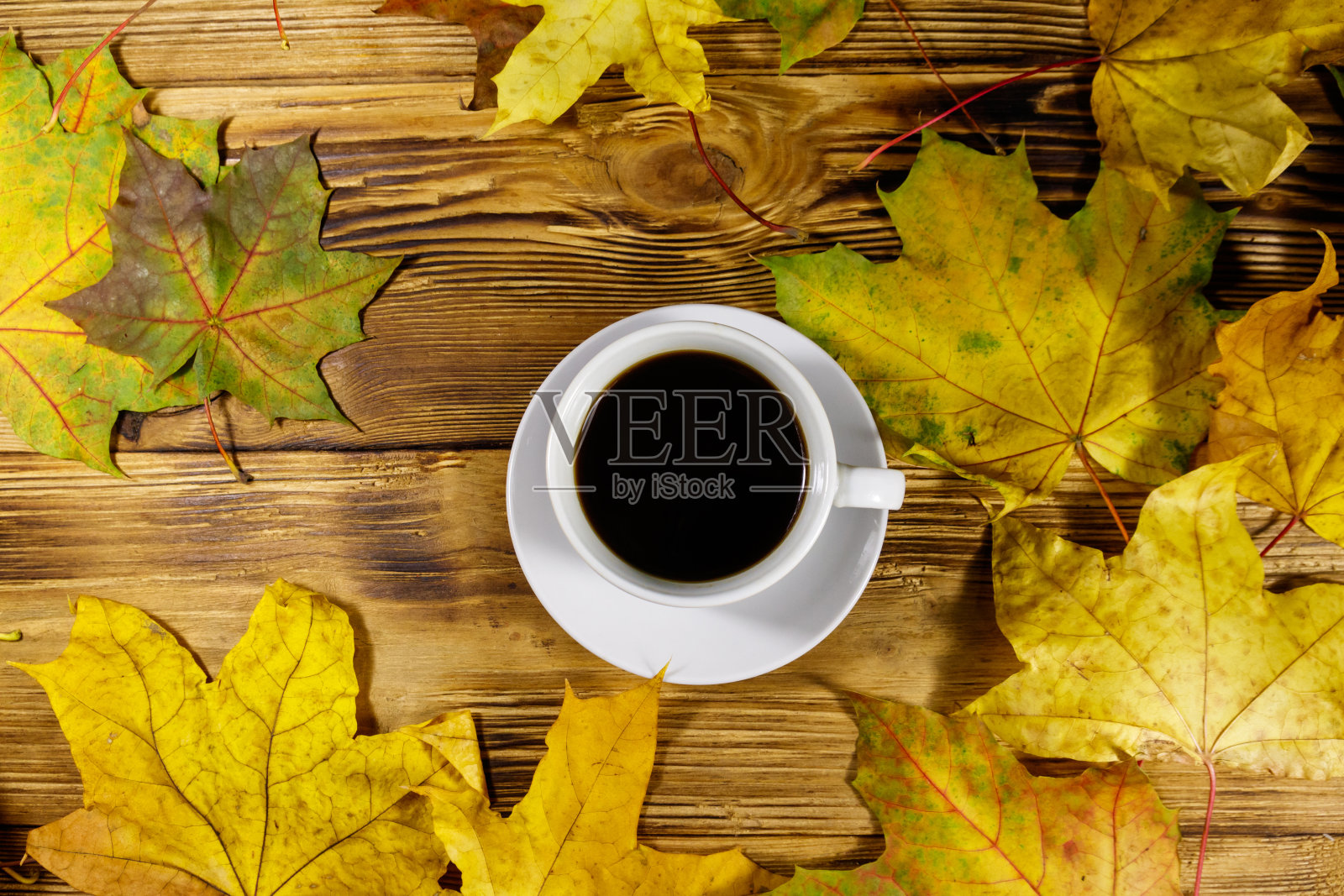 木桌上放着一杯咖啡和秋天的枫叶。前视图。秋天的概念照片摄影图片