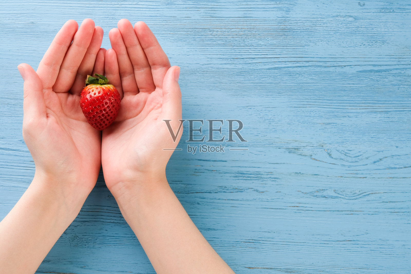 手里拿着草莓的女孩照片摄影图片