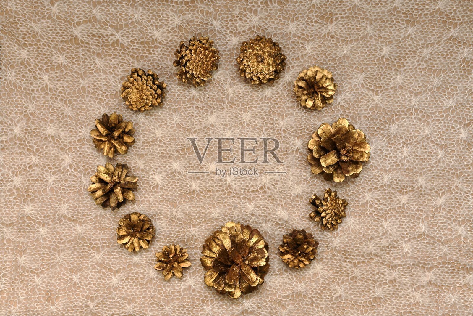 一个精致的镀金松果背景，俯视图，一个圆形的框架在中心，在针织帆布上，在温暖的光线。照片摄影图片