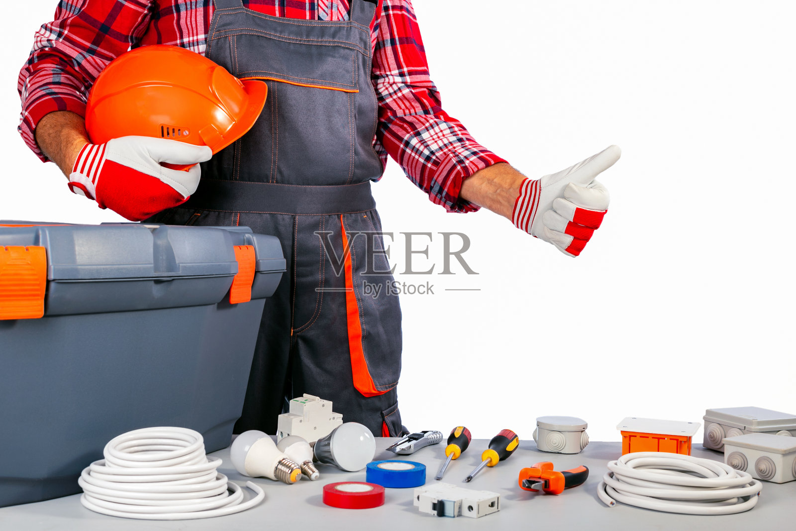 修理工拿着头盔，竖起大拇指。中小企业的概念。劳动节。照片摄影图片