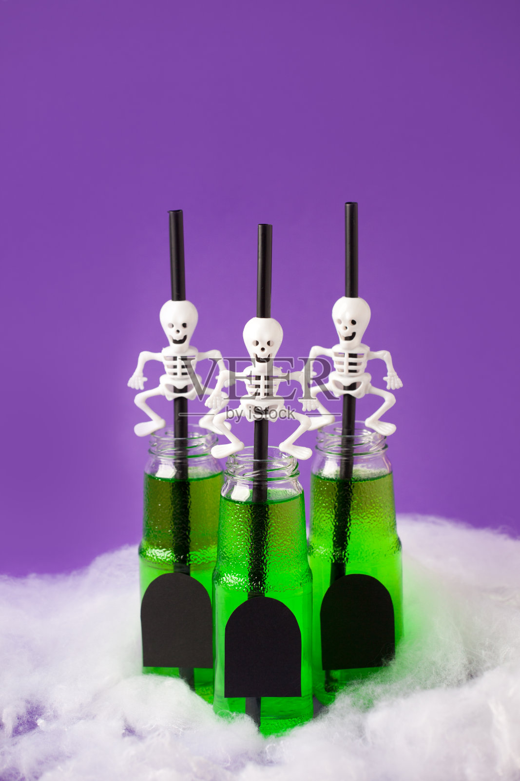 一套绿色女巫饮料在玻璃瓶与幽灵骷髅鸡尾酒吸管和坟墓拷贝空间，万圣节有趣的食物想法，明亮的祝贺，节日派对的邀请卡，菜单照片摄影图片