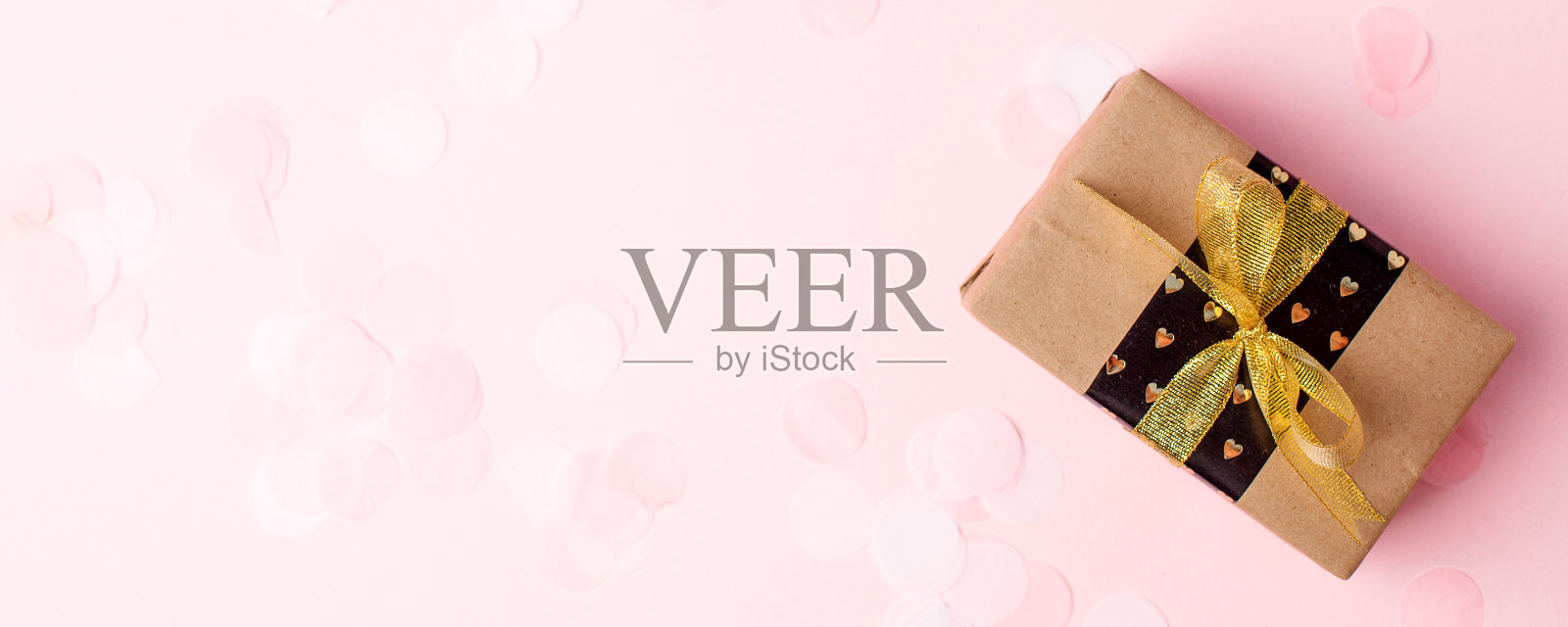 礼物或礼品盒与金色的蝴蝶结和五彩纸屑在粉红色的蜡笔桌顶视图。平铺作文为生日，母亲节，黑色星期五销售，新年，圣诞节，横幅，拷贝空间，传单，优惠券照片摄影图片