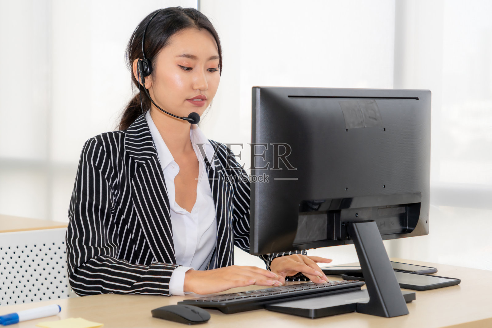 商务人员戴着耳机在办公室工作照片摄影图片