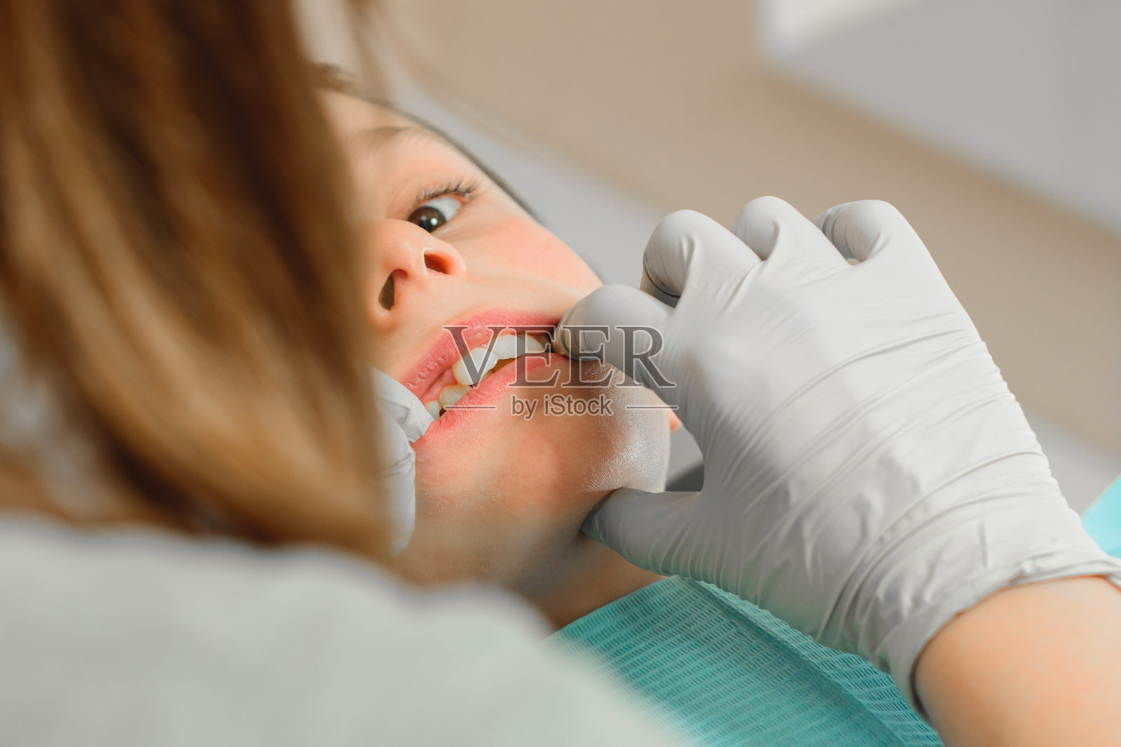 牙齿矫正医生为男孩检查牙齿。照片摄影图片