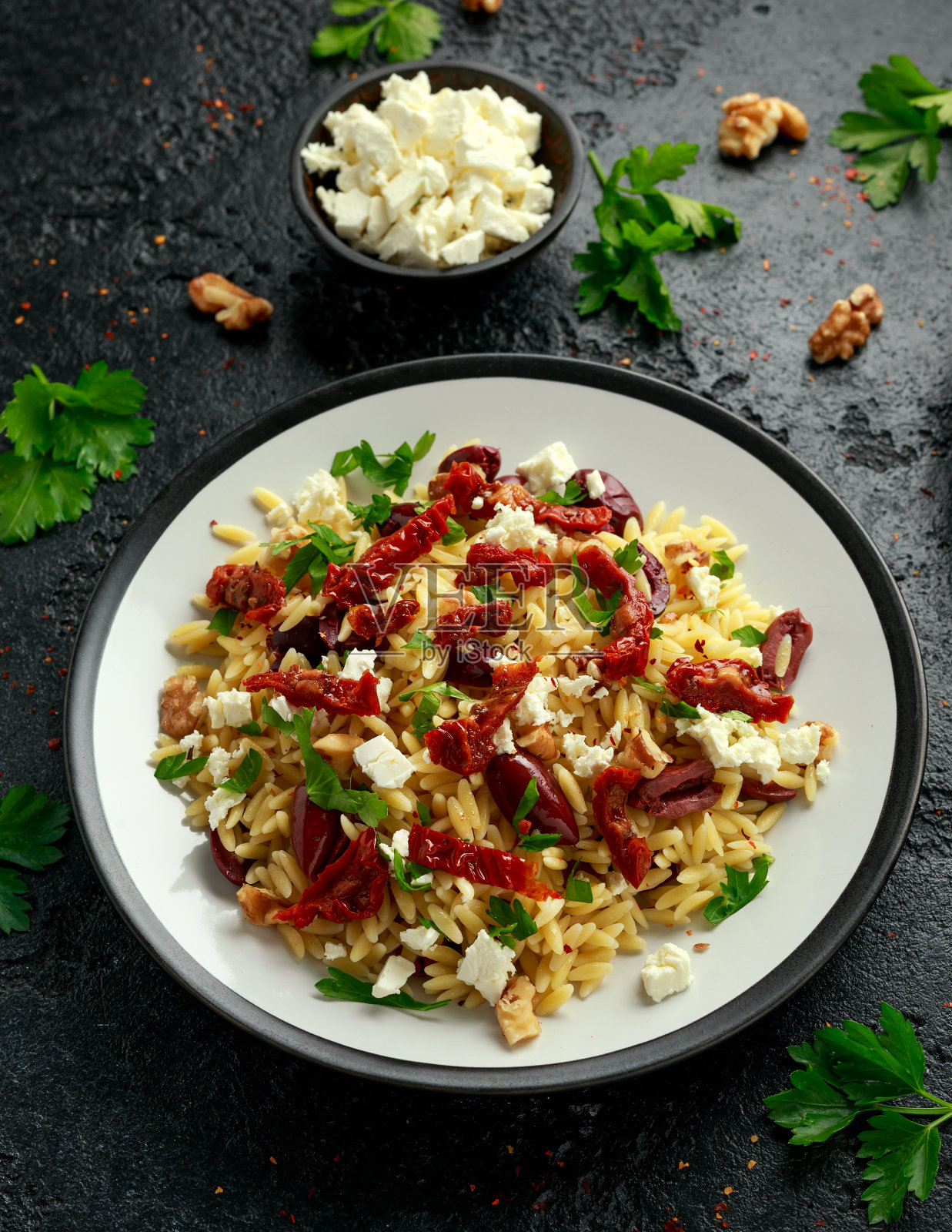 意大利米粉配番茄、黑橄榄、核桃和羊乳酪照片摄影图片