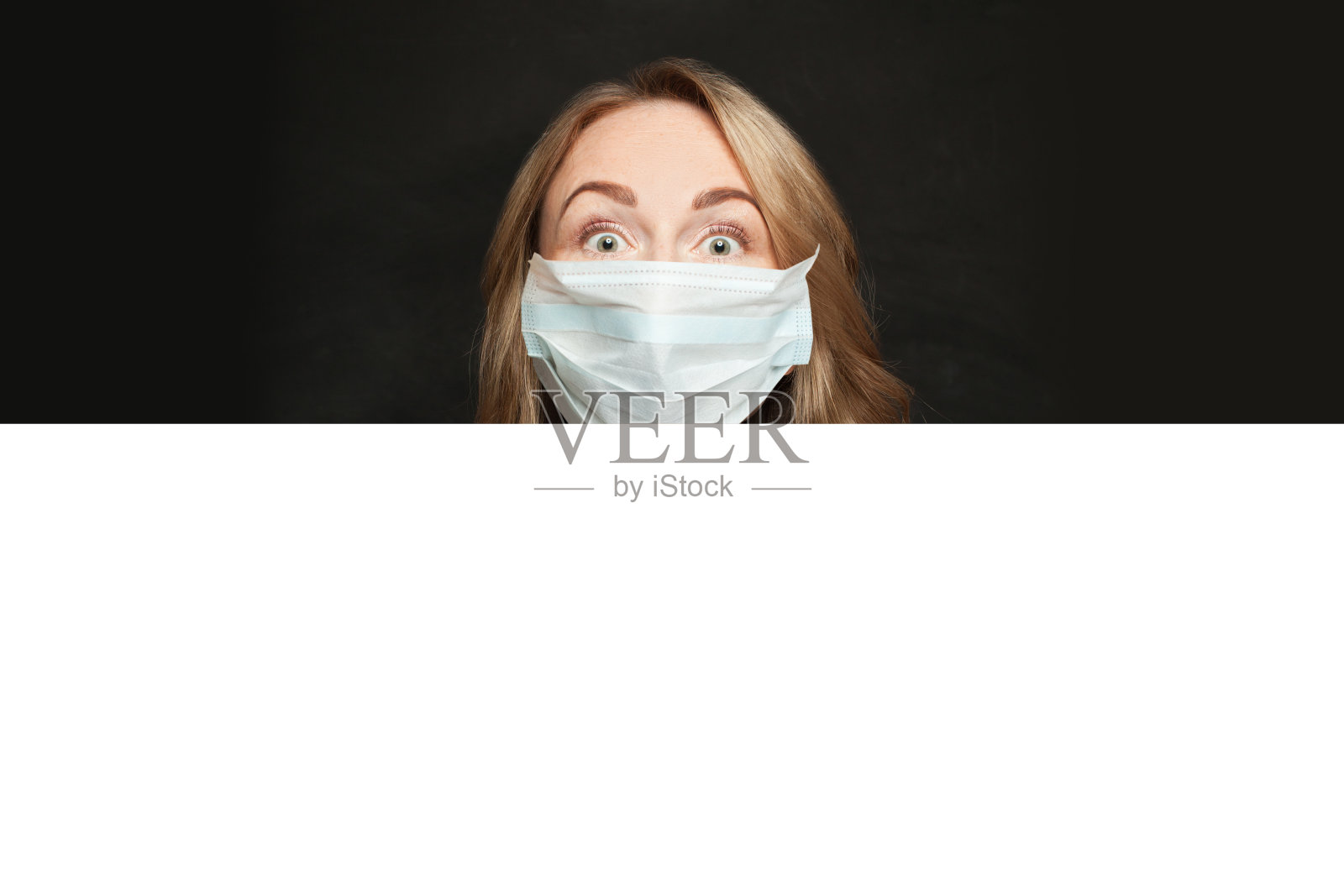 妇女在医疗防护口罩与白色空白纸招牌横幅在黑色背景照片摄影图片