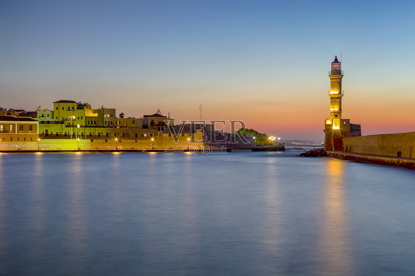 风景如画的查尼亚老中心与古威尼斯港和灯塔在蓝色小时在克里特岛，希腊。水平的形象照片摄影图片