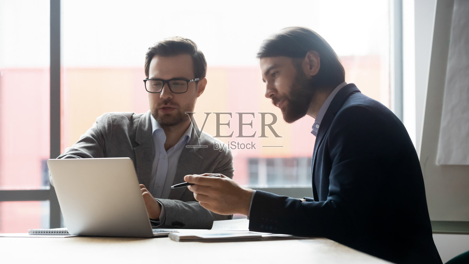 男同事一起在笔记本电脑前头脑风暴照片摄影图片