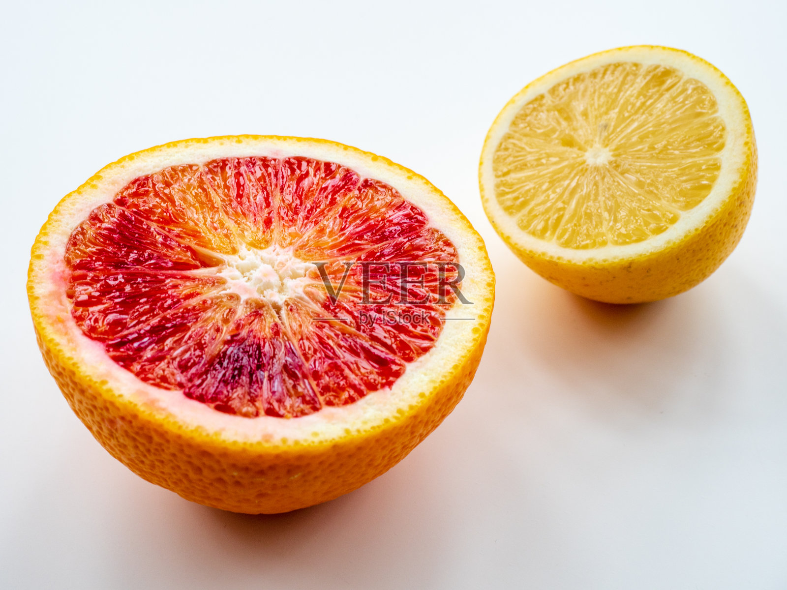 特写:在白色的背景上，橙色和柠檬的一半照片摄影图片