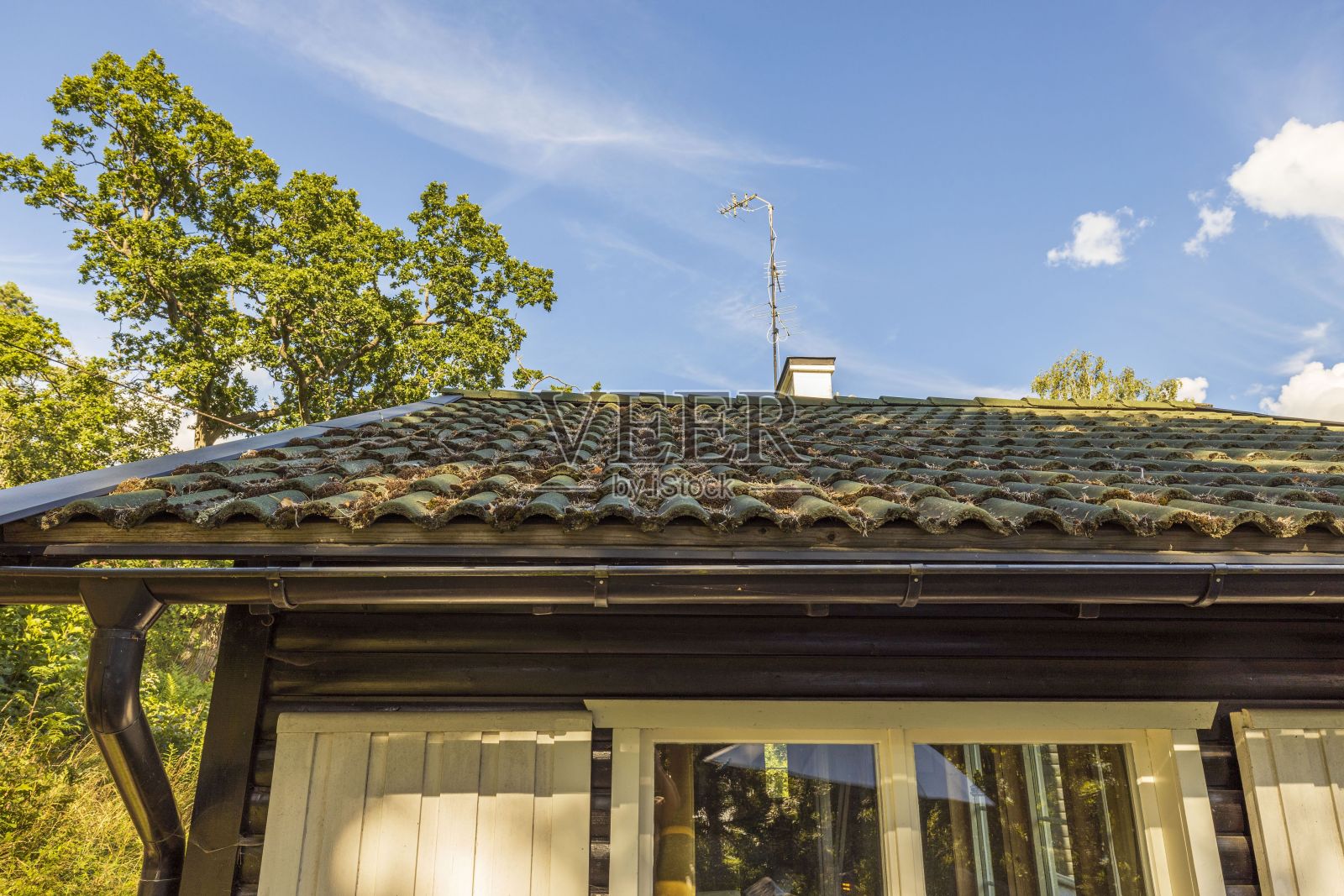 深灰色的老瓦屋顶在蓝天的背景下美丽的景色。美丽的背景。照片摄影图片