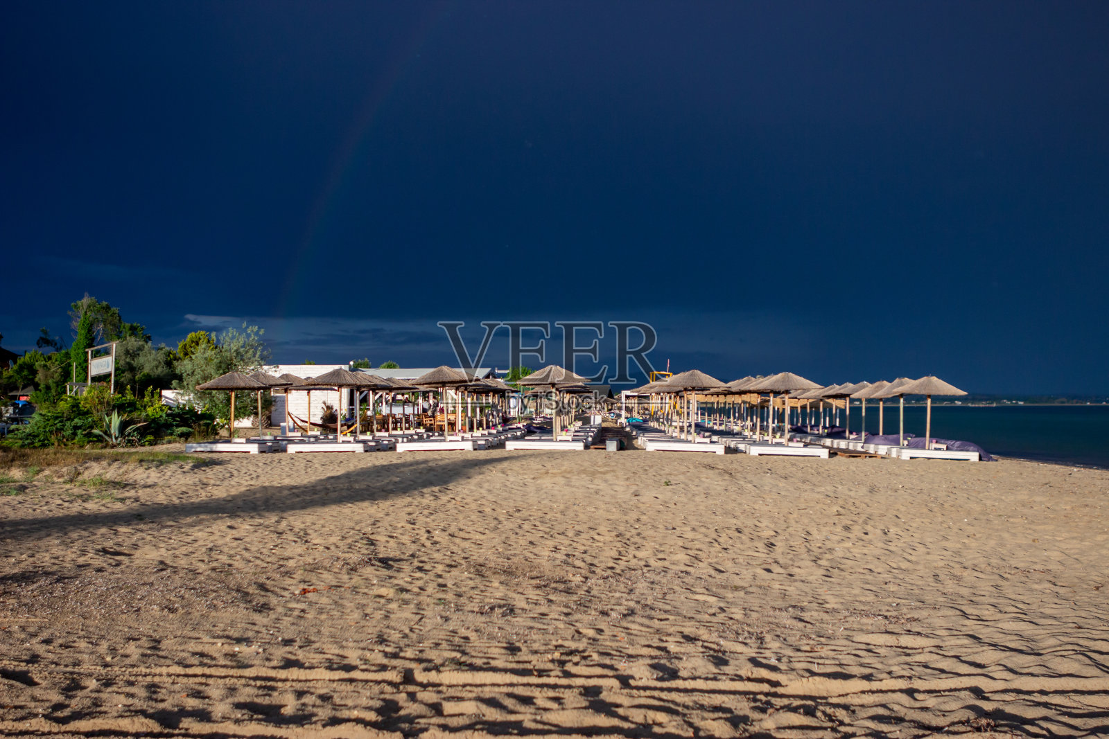 深蓝色的天空在海边的沙滩上。就像一场暴风雨。海滩空无一人，也没有人。照片摄影图片