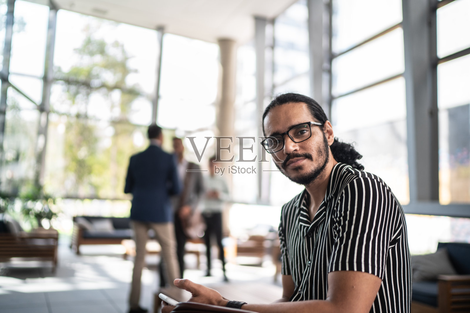 一个商人在大堂办公室使用手机的肖像照片摄影图片