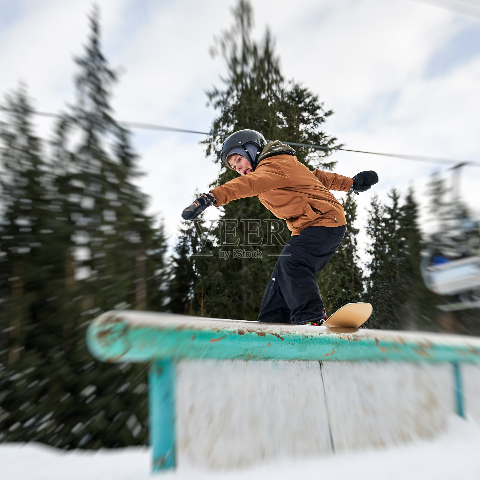 一个年轻人在滑雪胜地玩滑雪板。照片摄影图片