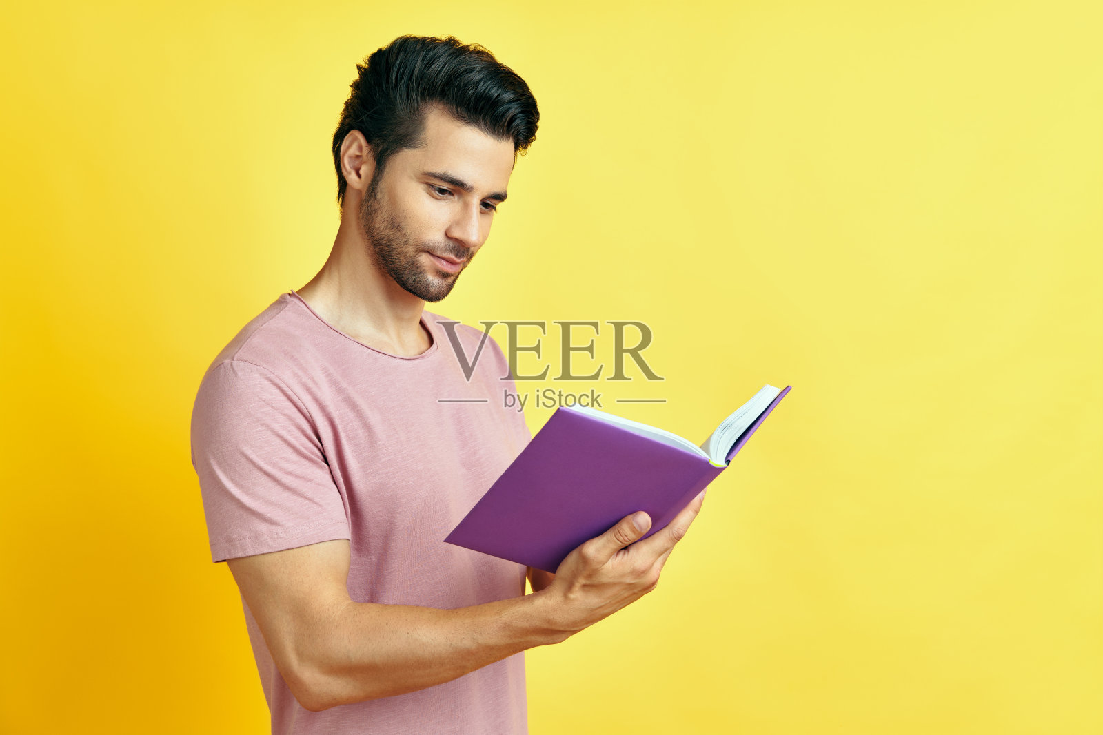 英俊的年轻人穿着休闲的衣服读着一本书照片摄影图片