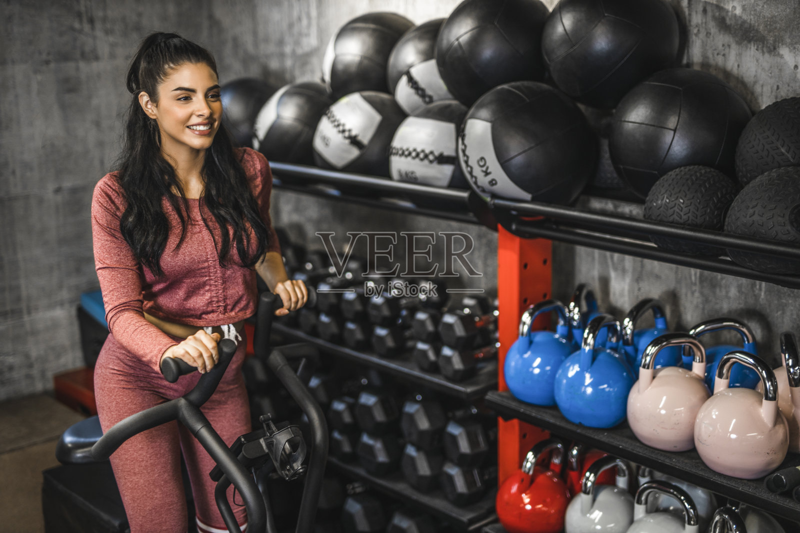 年轻的健康女子正在健身房里的自行车上进行运动训练照片摄影图片