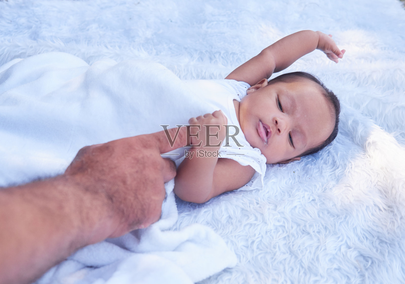 一个可爱的小女孩牵着她爸爸的手。一个漂亮的小女孩的肖像。照片摄影图片