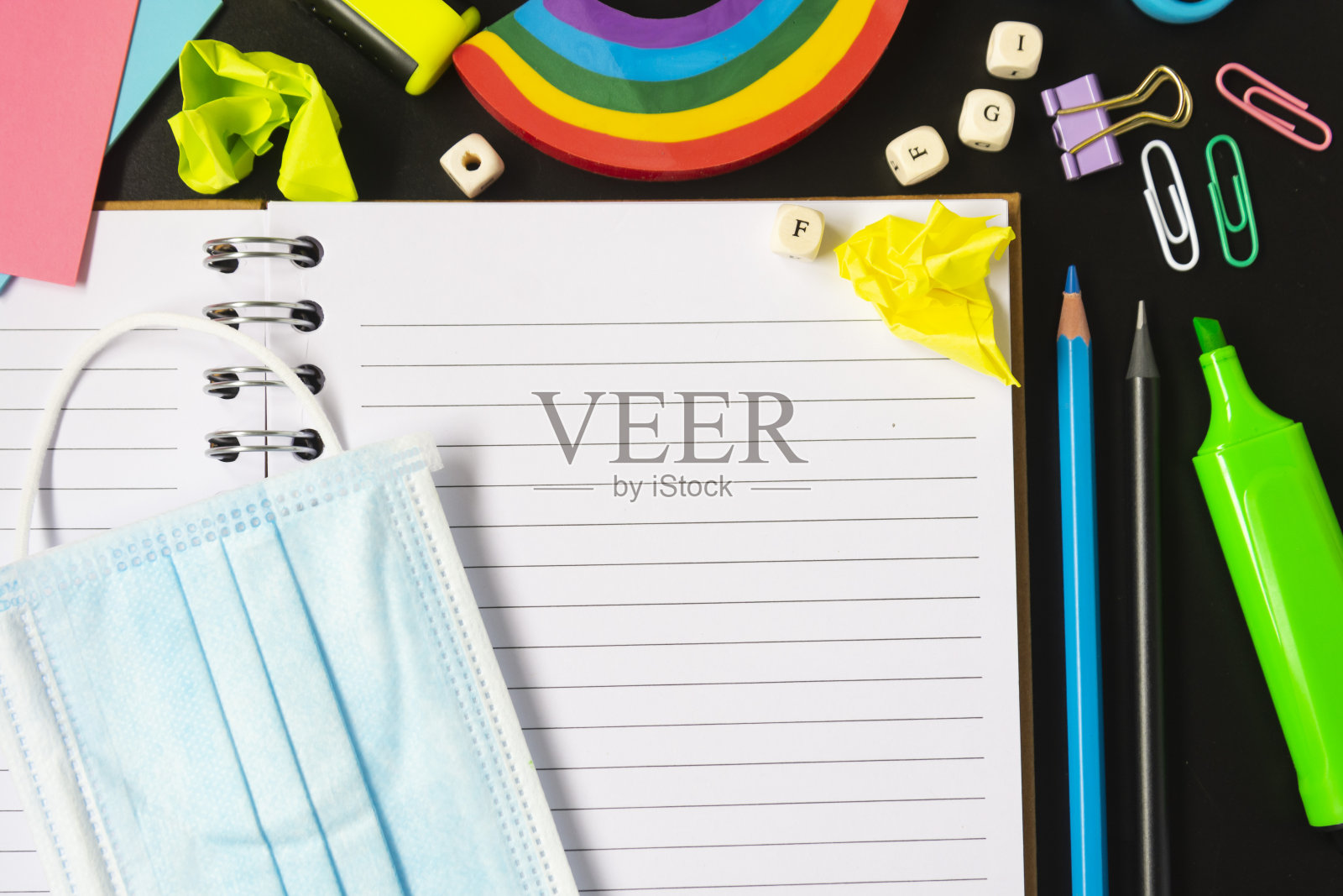 俯视图打开笔记本与面具，彩色铅笔，彩虹橡皮，笔记本，便利贴。平的。照片摄影图片