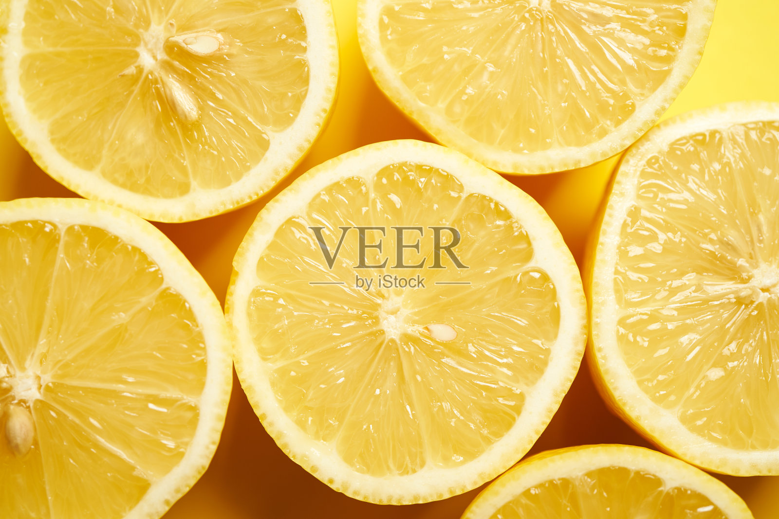 黄色极简主义背景上的新鲜柠檬照片摄影图片