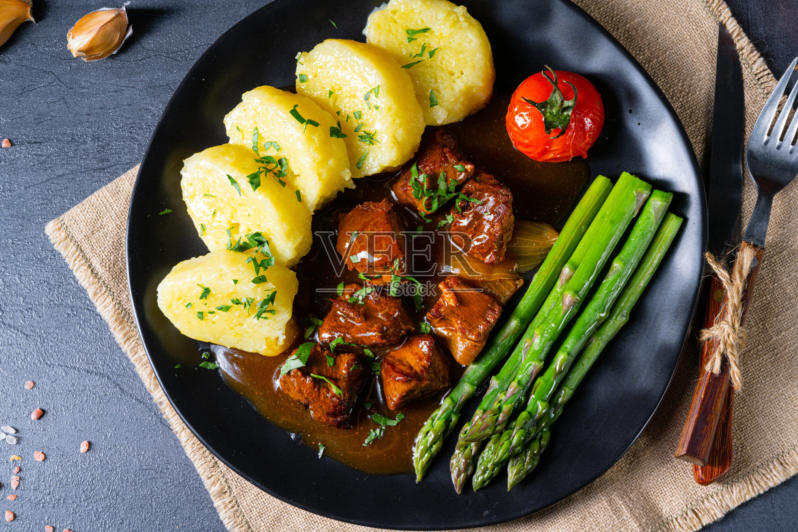 炖牛肉和绿芦笋的饺子照片摄影图片
