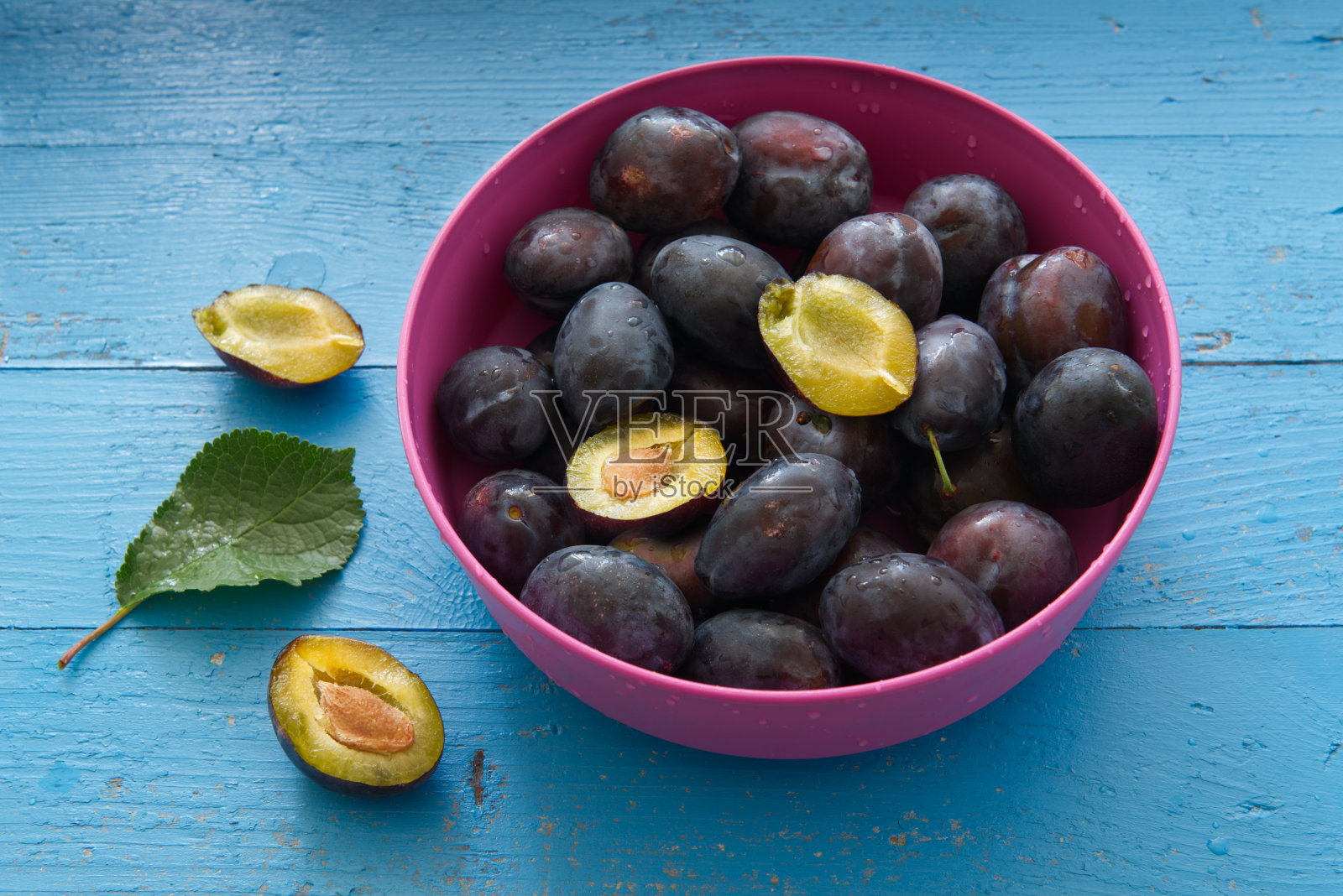 青色木桌上的菜里有李子照片摄影图片
