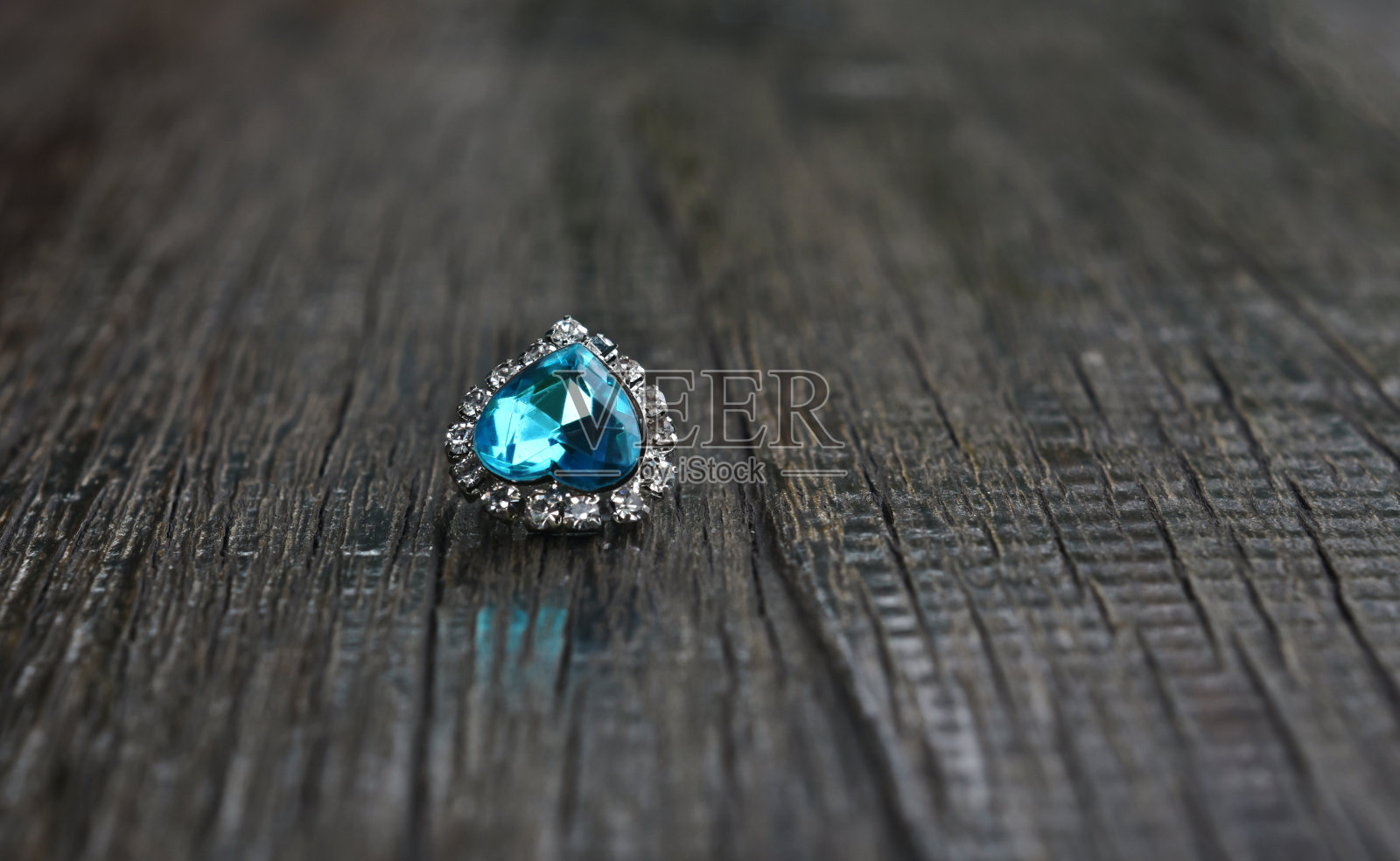 白金项链垂饰心型海蓝宝石放在木地板上。照片摄影图片