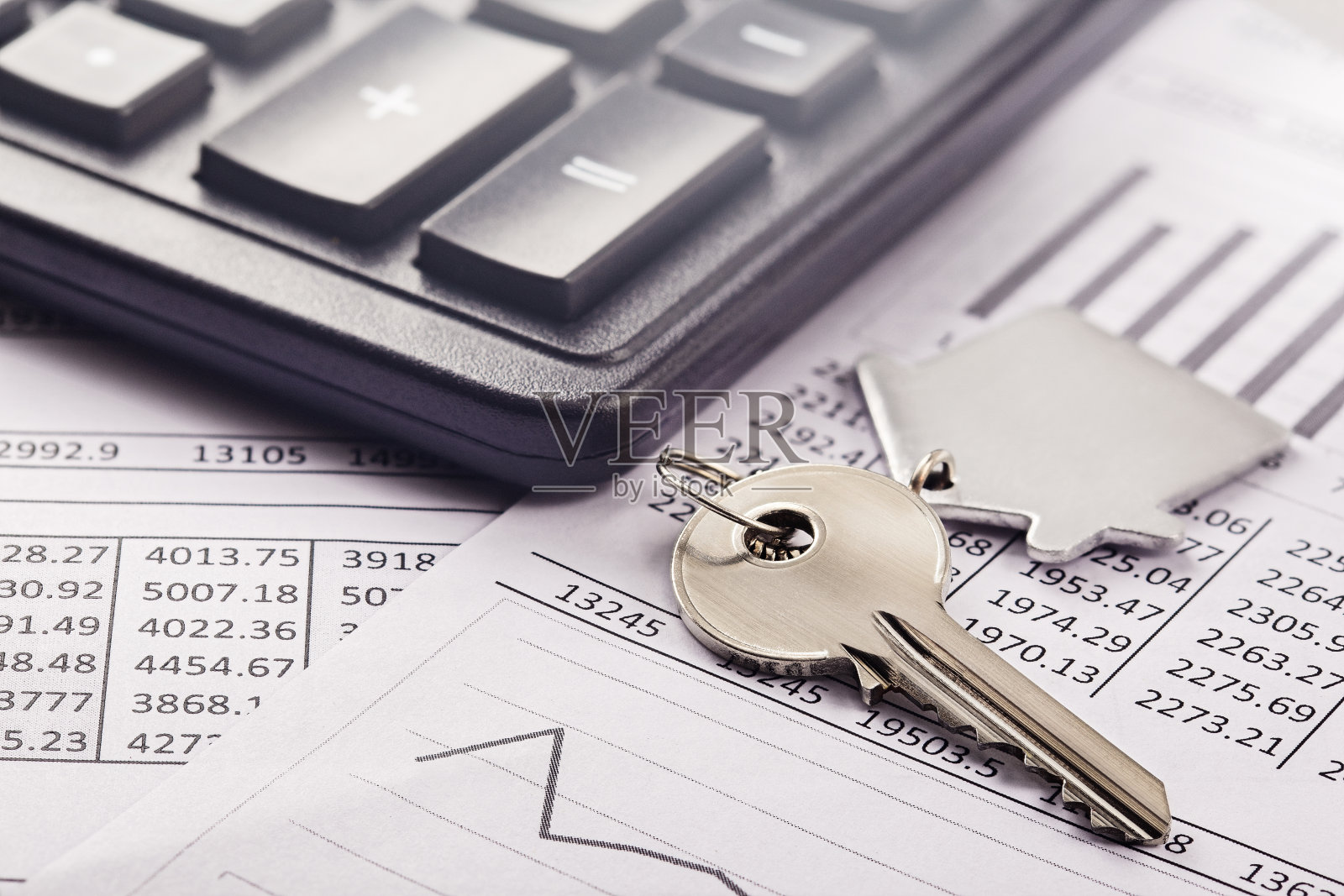 房产，带房子标志的钥匙链。计算器与财务空白。照片摄影图片
