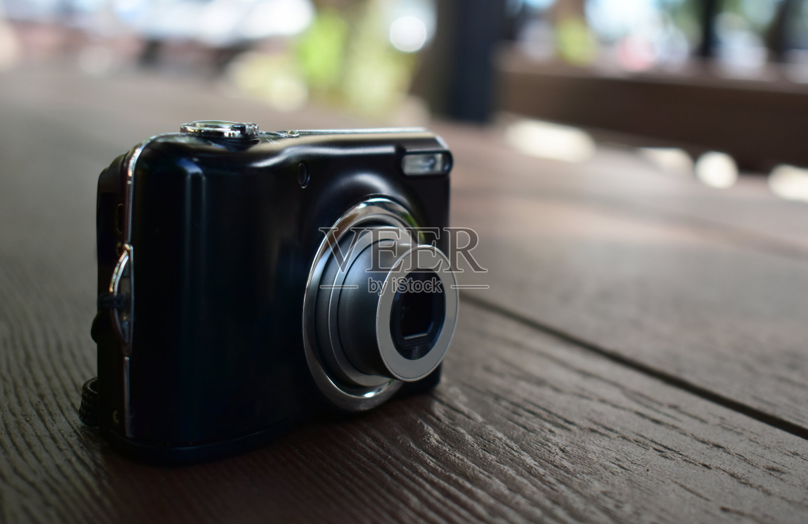 袖珍数码相机黑色在手和照片。照片摄影图片