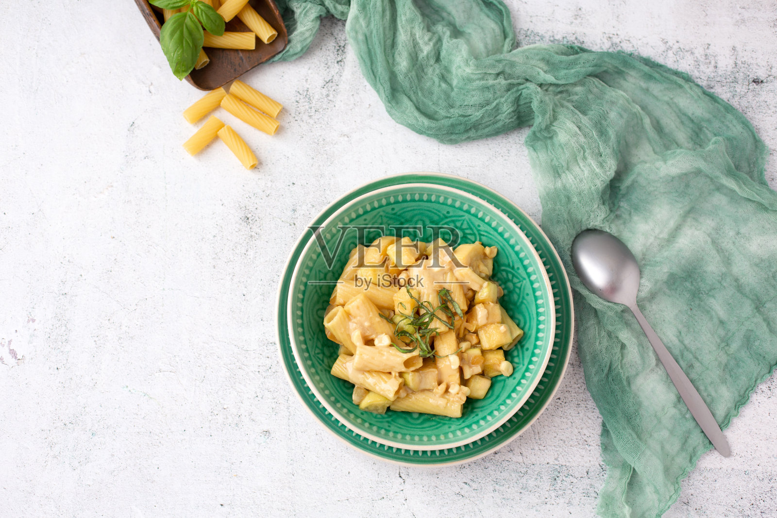 素食通心粉在一个绿色的碗在一个白色的背景照片摄影图片
