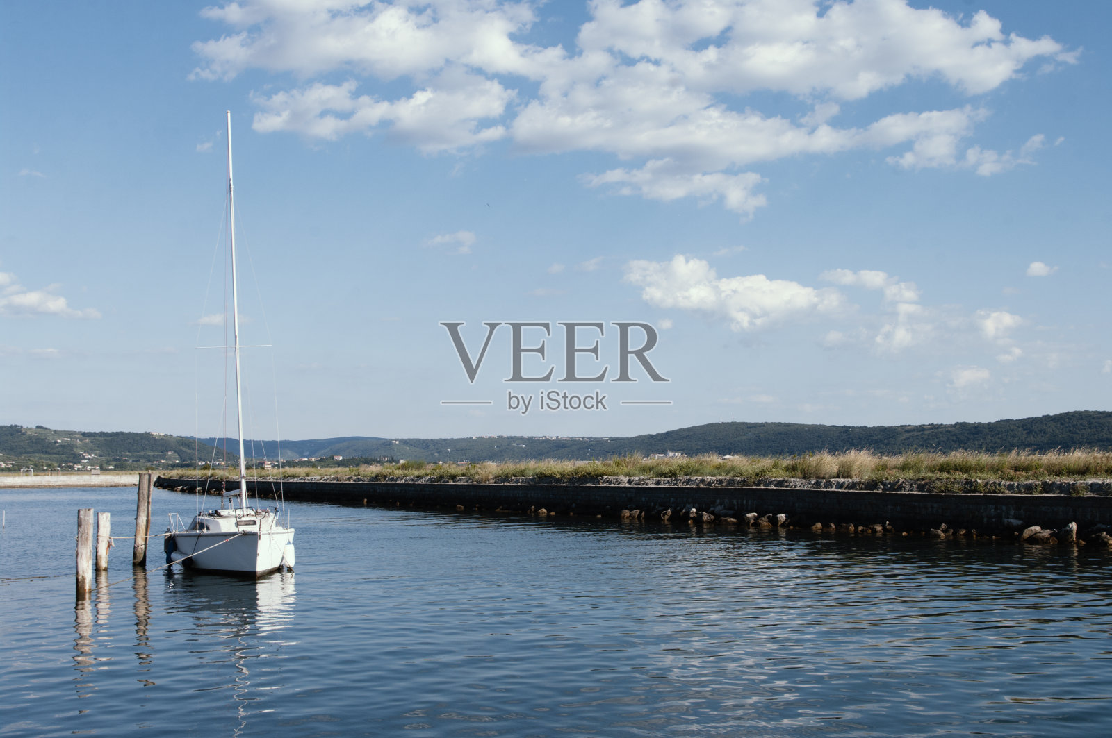 白色游艇和蓝色的水亚得里亚海，斯洛文尼亚。晴朗的天空和小云。航海照片摄影图片