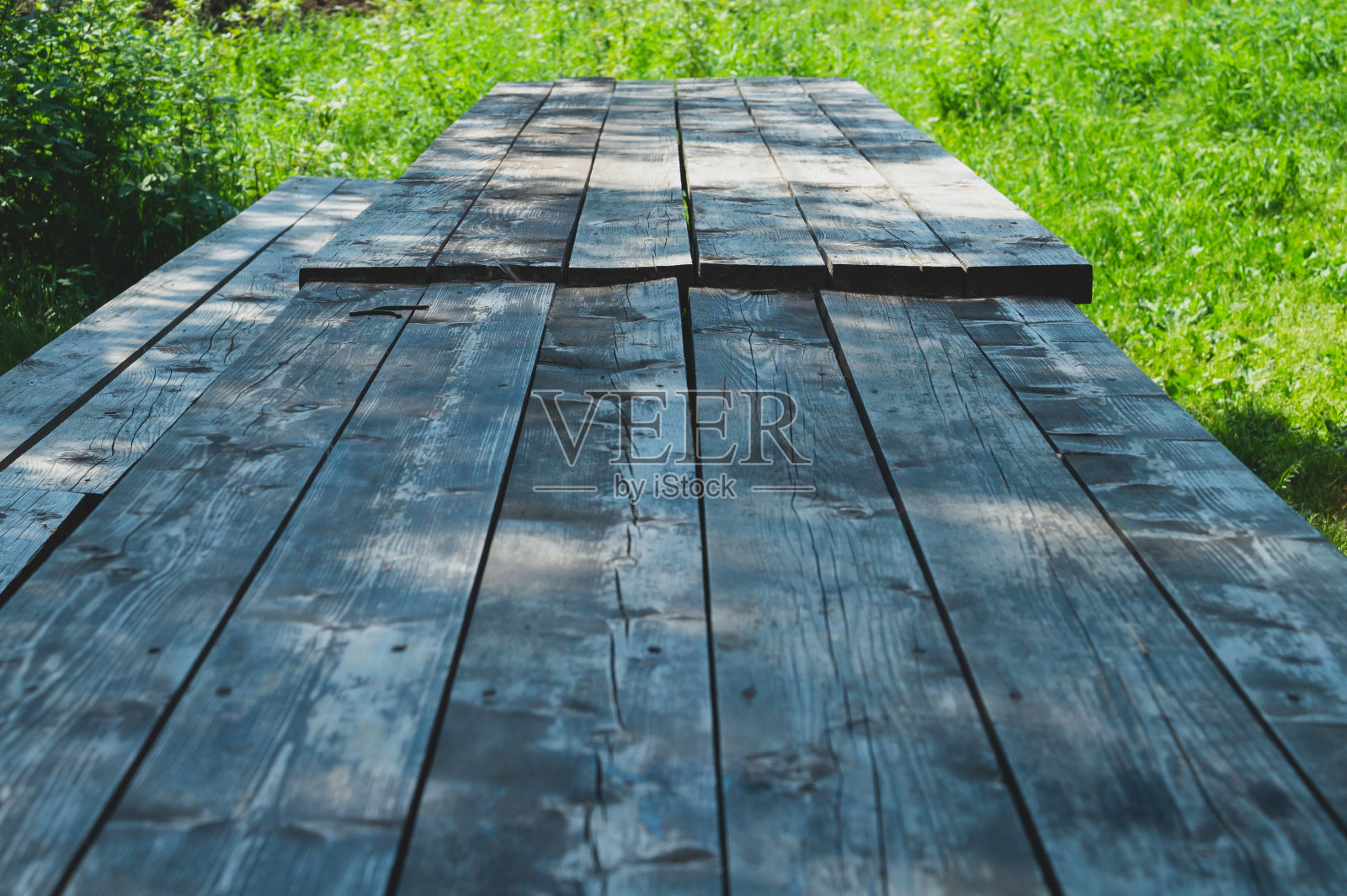 公园里的木桌。夏天的一天。绿色的树叶照片摄影图片